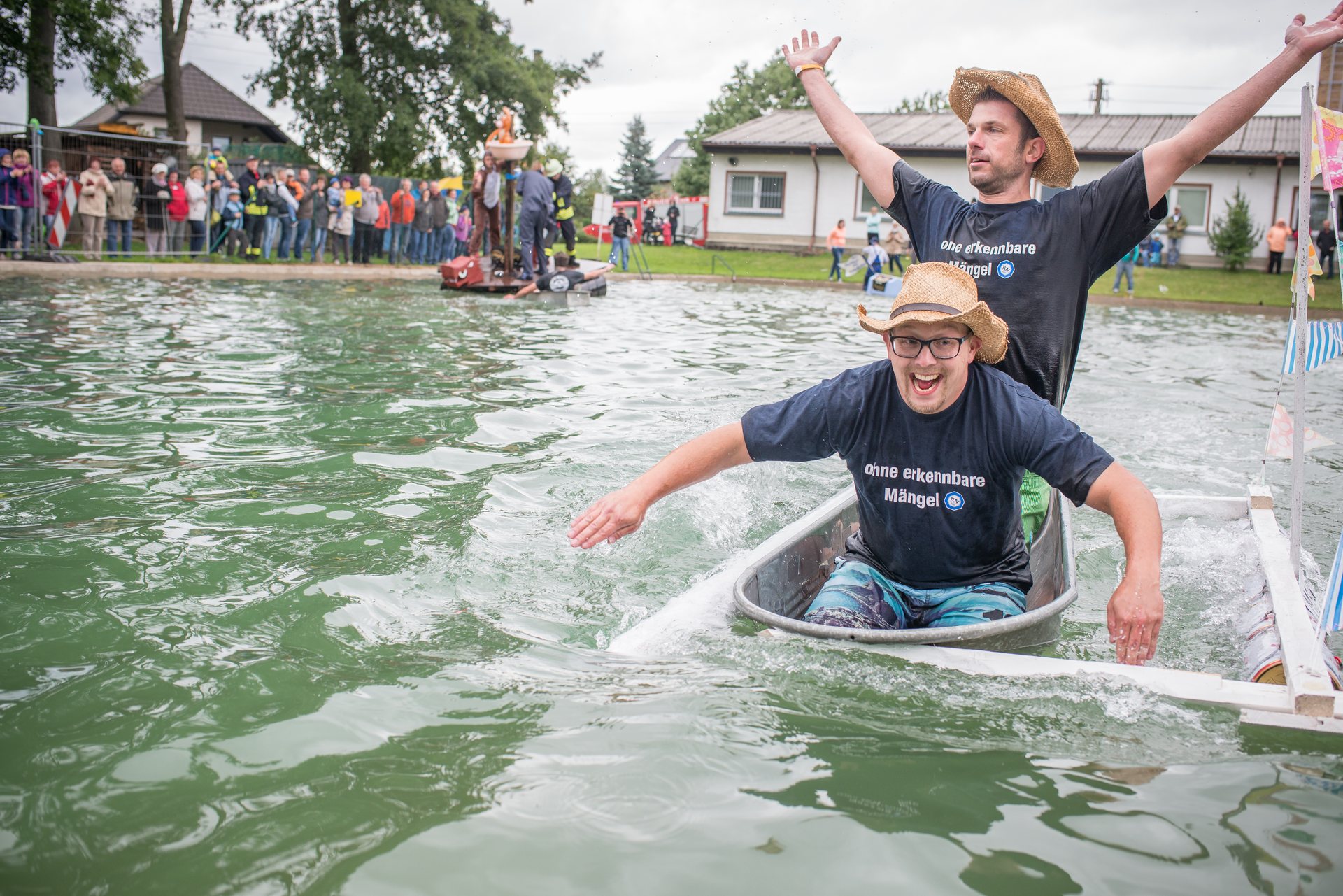 Teilnehmer beim Badewannenrennen auf dem Wasser.